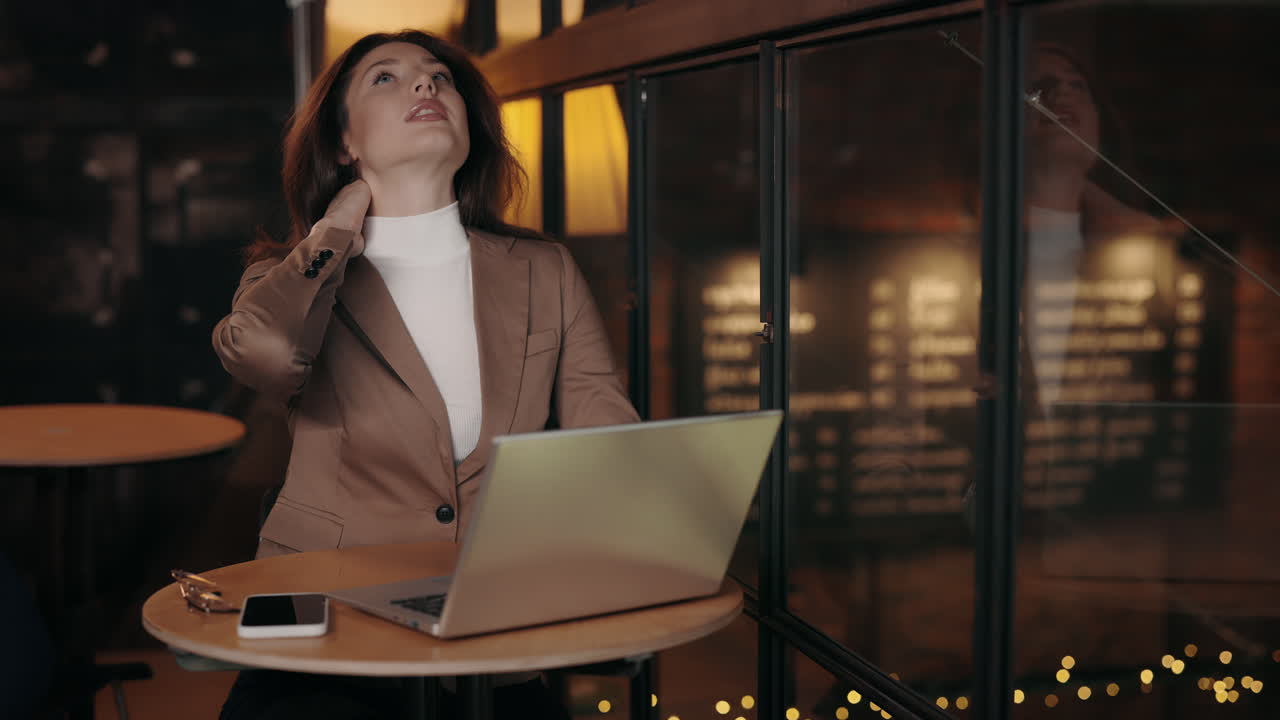 Woman with neck pain working on laptop