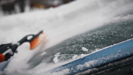 quitar la nieve del parabrisas de un coche en invierno