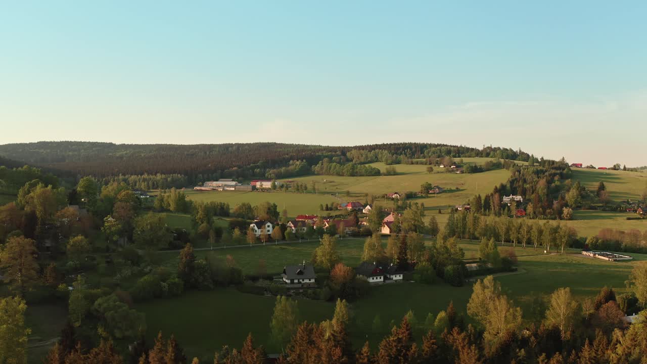 해가 지는 동안 숲으로 둘러싸인 체코 고원 마을의 드론  ⁇