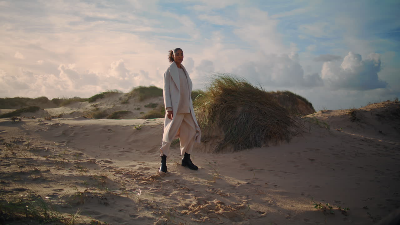 mujer tranquila girando playa a la luz del sol. solitaria chica de cabello negro admirar disfrutar de la arena