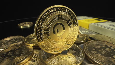 Rotierende-Goldene-Polkadot-Münze-Auf-Einem-Stapel-Kryptomünzen-Mit-Papiergeld-Auf-Schwarzem-Hintergrund,-Kryptomarkt,-4K-Aufnahme