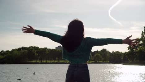 gorgeous italian woman with arms raised looking at sunset view over the lake