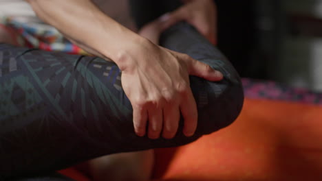 male thai masseur working out a female client's hips while pulling on her knee