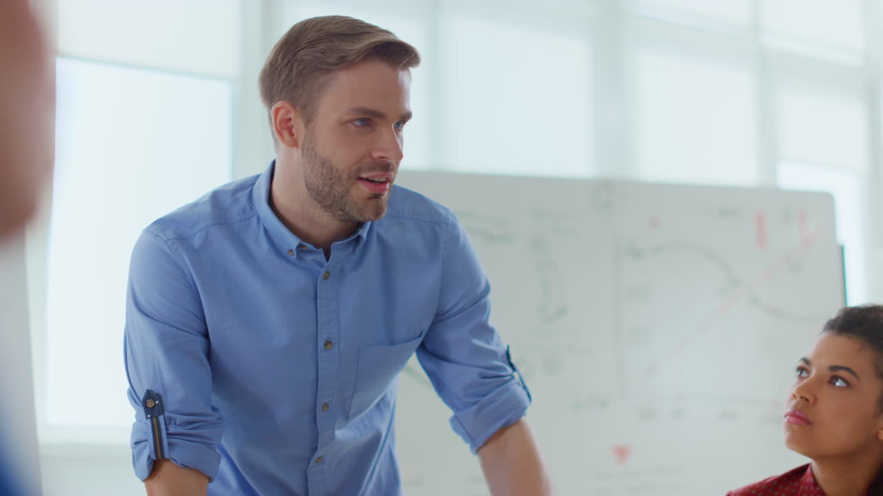 un hombre de negocios hablando con un colega de oficina, un líder de equipo haciendo una lluvia de ideas con la gente.