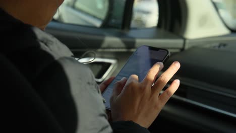 individual browsing phone while seated in vehicle