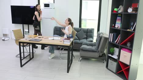 Two women talking in an office space