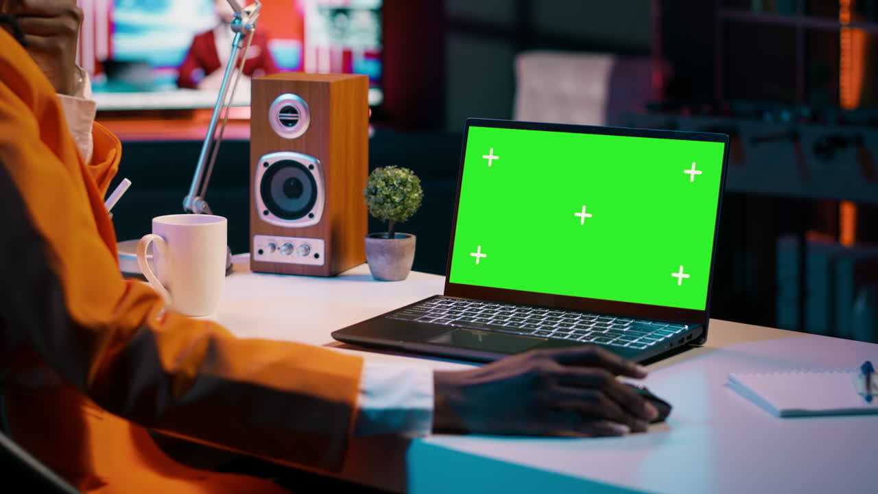 joven usando una computadora portátil con pantalla verde aislada en su oficina en casa