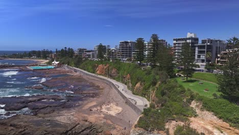 Aerial-view-of-the-high-rise-buildings-of-Wollongong-and-the-beach-path-and-pools-beyond