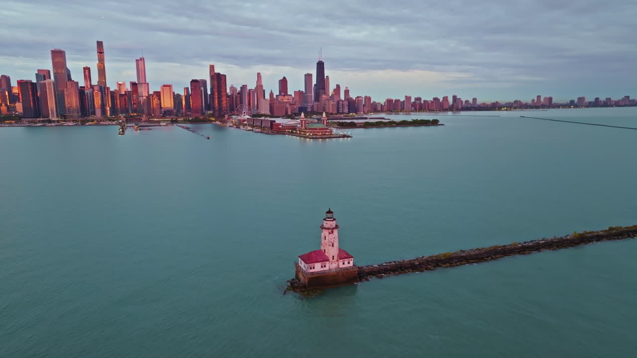 Aerial view around the sunlit Chicago Harbor Lighthouse with skyline background