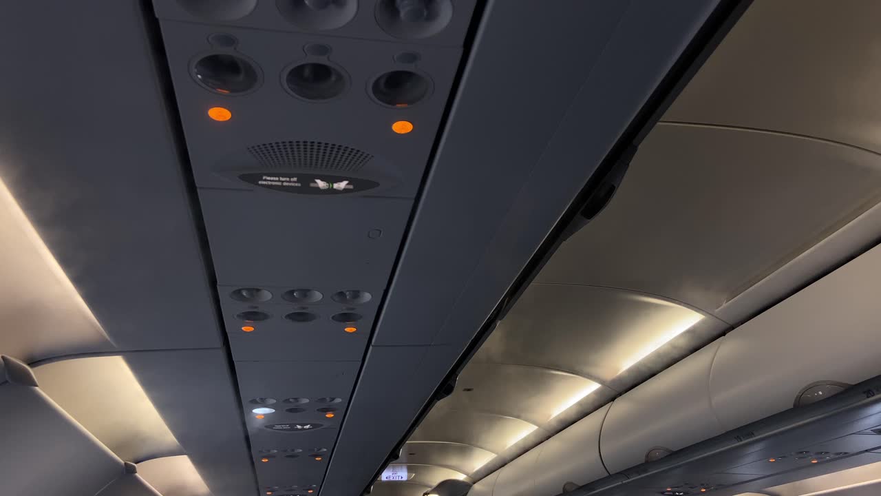 Static shot of the mist from air condensation unit blowing inside modern airplane cabin