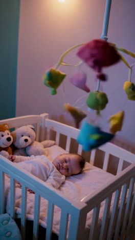 baby sleeping in crib with mobile