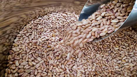 primer plano de frijoles rojos crudos que caen de una taza en un contenedor en el supermercado