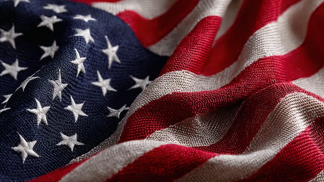 Et nærbillede af den intrikate tekstur og de levende farver i et amerikansk flag, der indfanger essensen af patriotisme og national stolthed i dets stofdesign.