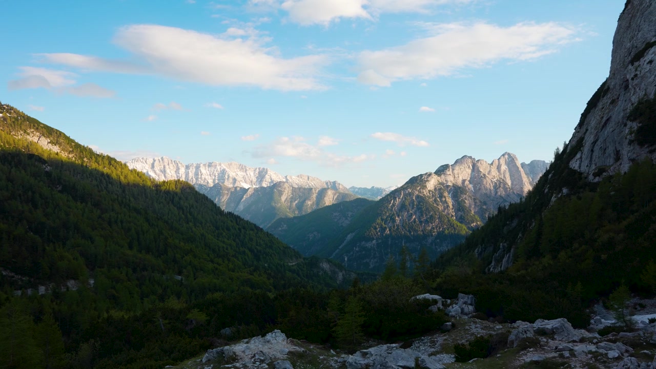 Schwenkende Panoramaaufnahme zur goldenen Stunde des spektakulären Vršič-Pass-Alpentals mit den fernen Julischen Alpen, Oberkrain, Slowenien.