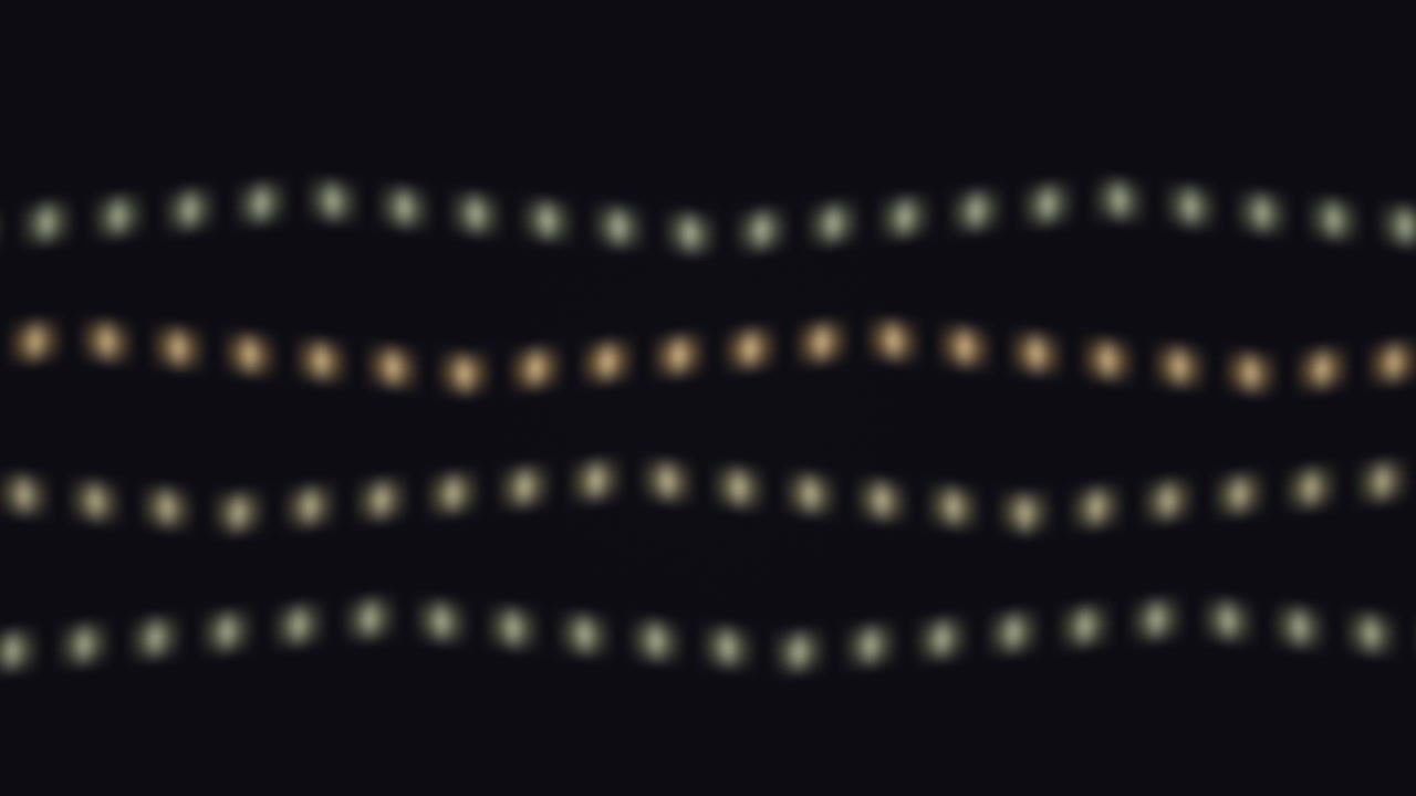 Light dots form wavy lines against a dark background. The arrangement shows motion and rhythm, creating an engaging visual experience in a simple design
