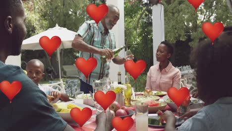 animation oh heart balloons over happy african american family dining in garden