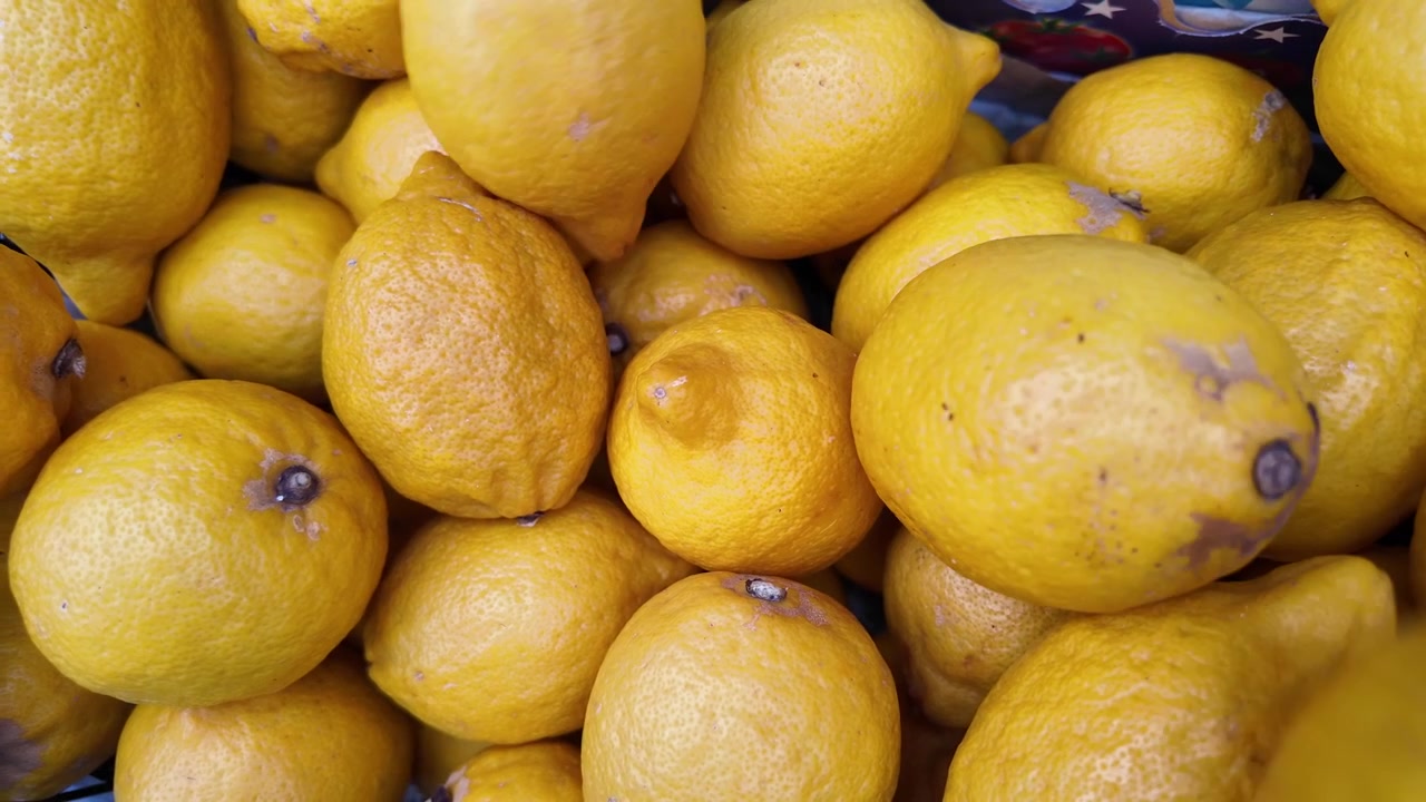 Limoni gialli freschi che cadono a formare un mucchio.