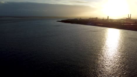 Sea-aerial-viewing-over-the-Isle-of-Grain,-United-Kingdom,-during-sunset-golden-hour