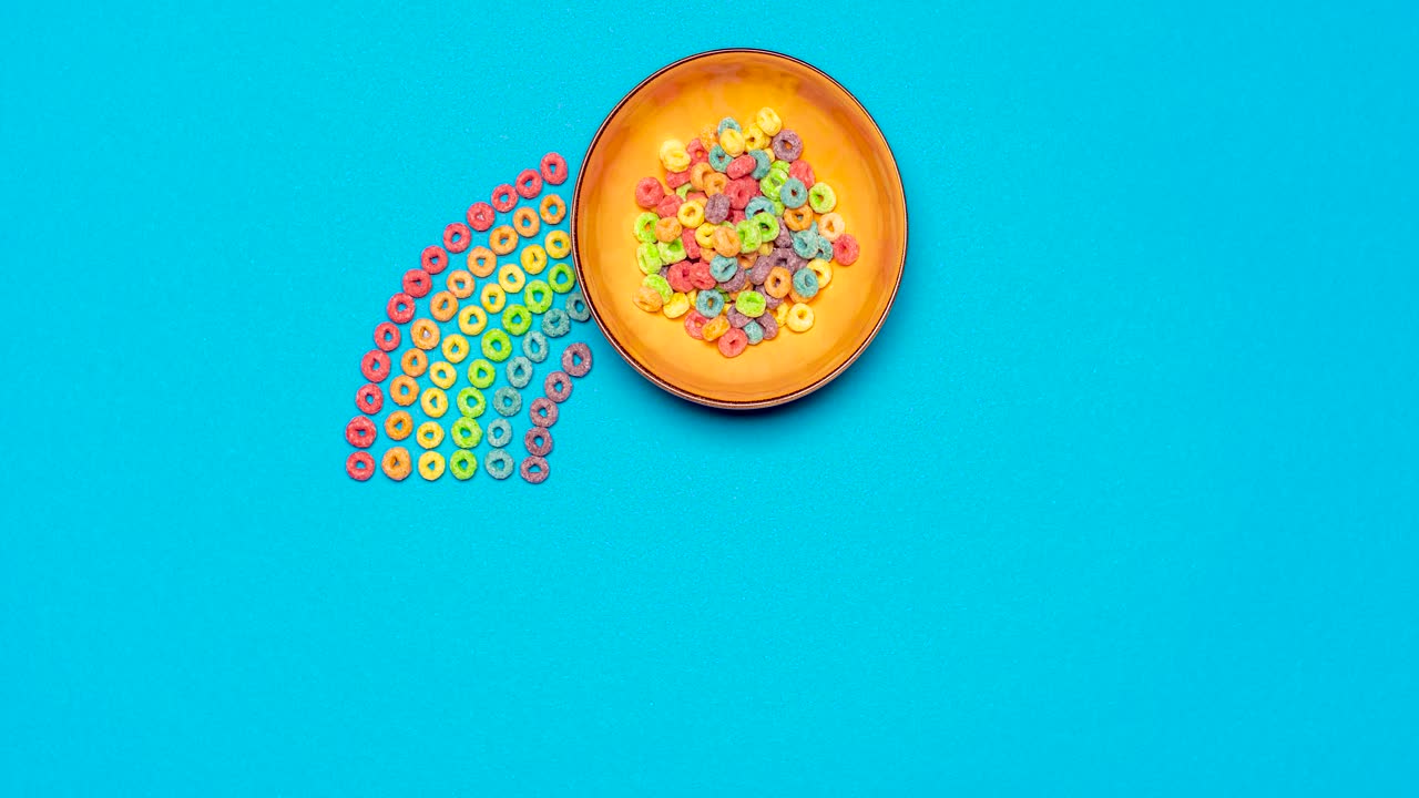 cereales coloridos con leche, animación en stop motion. cereales arco iris para el desayuno, vista de arriba