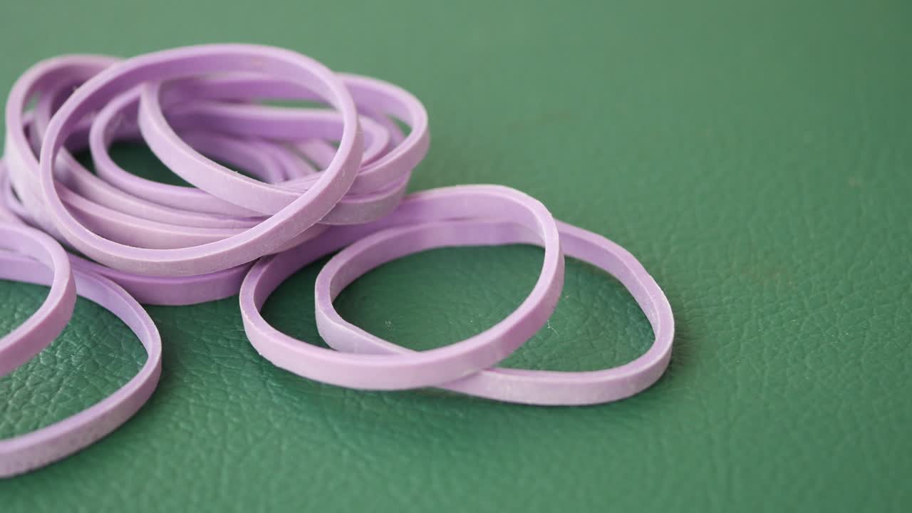Purple Rubber Bands on Green Surface
