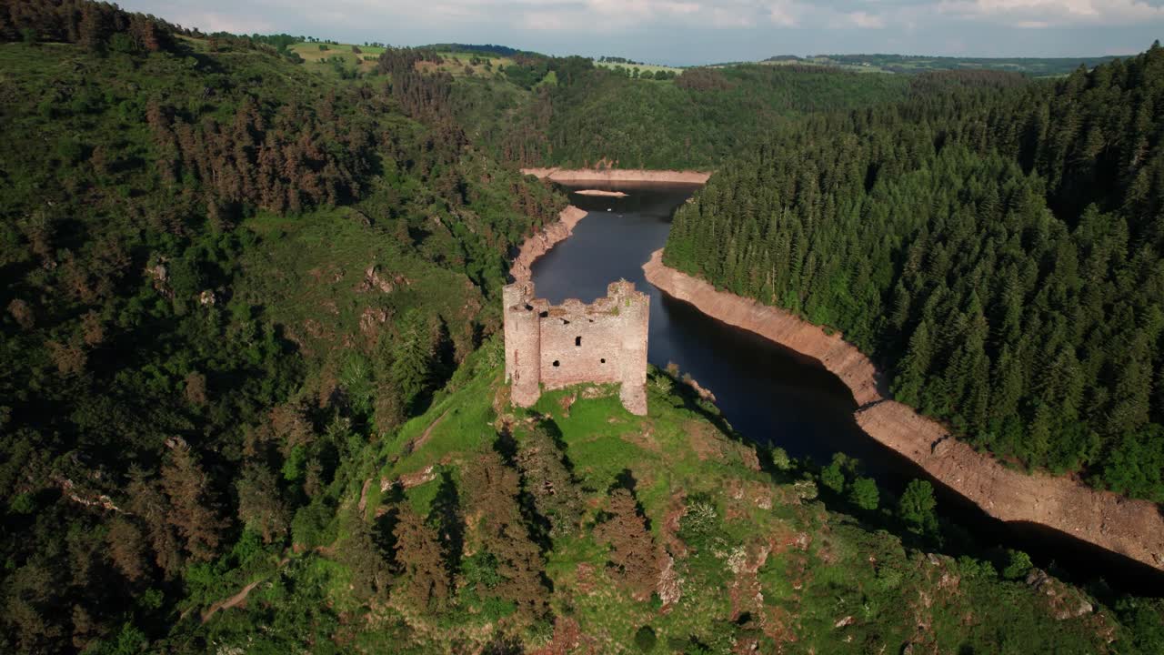 aerial shot going forward revealing Alleuze Castle and the Truyere river in the background on a partially cloudy day of summer, cantal departement, Auvergne Rhone Alpes region, France