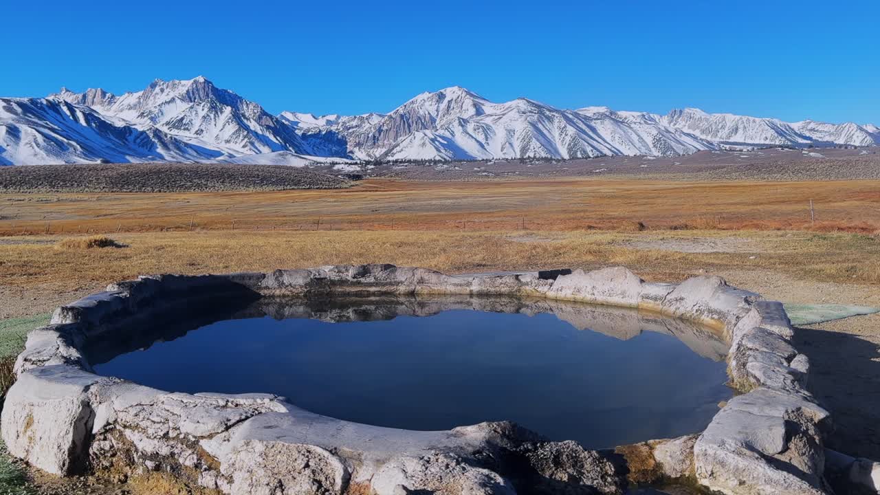 Winter early morning blue sky natural Hilltop Whitmore Wild Willys Hot Springs hot tub soak sunny sky snow covered Mammoth Mountain Minarets aerial drone Convict Canyon peaceful steam left slide