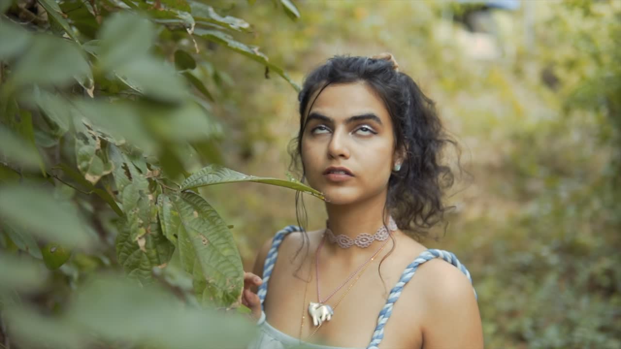 Cinematic shot of a fashion model looking up towards the sky in the tropical rainforest of Goa, India, Slow Motion, Slomo