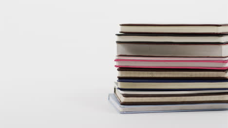 acercamiento de una pila de libros sobre un fondo blanco, en cámara lenta