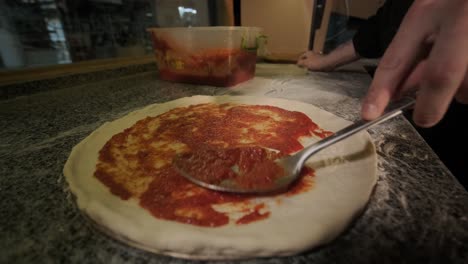 man cooking pizza in the kitchen of restaurant