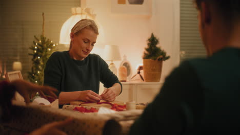 woman wrapping gift boxes with friends