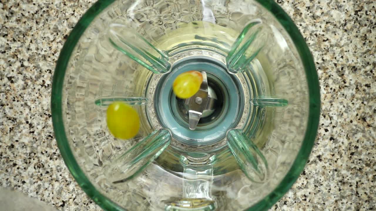 Grapes fall in a blender bowl. Slow motion. Shooting in kitchen. Top view
