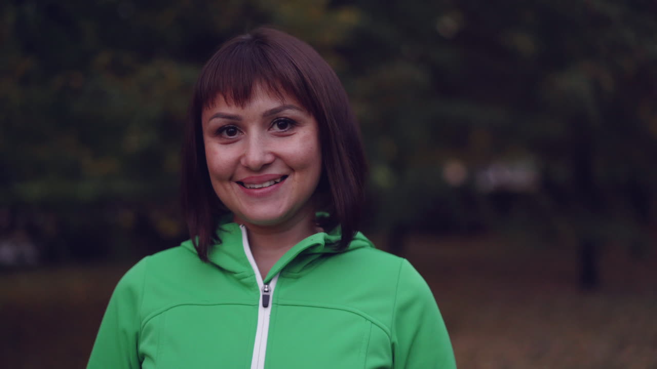 Woman in a Green Jacket in an Autumn Park
