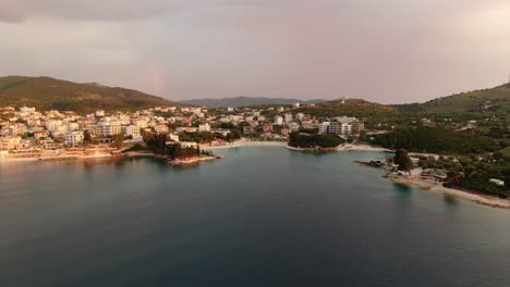vista de avión no tripulado en albania volando sobre aguas cristalinas azules al atardecer, pequeñas islas verdes y hoteles en ksamil