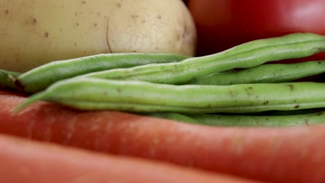 Close-up,-pan-right-of-green-beans,-carrots,-potatoes-and-tomatoes