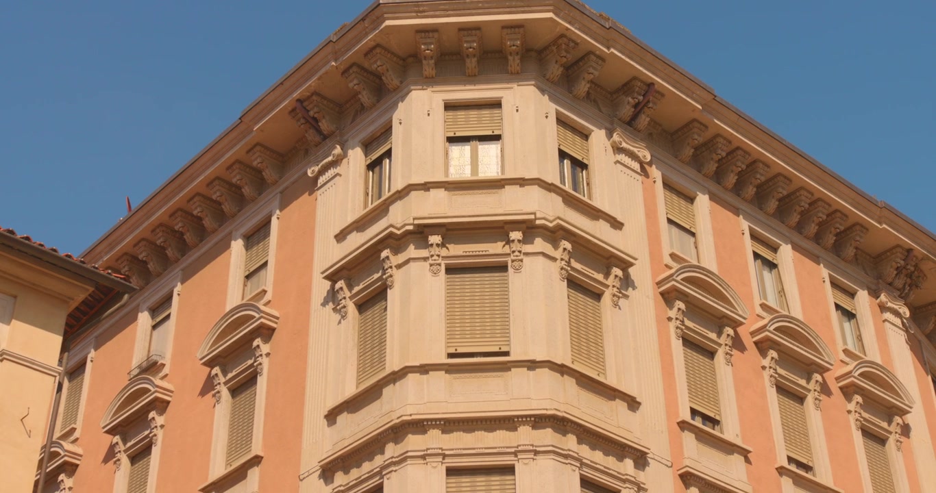 Vista de baixo ângulo de fachada de edifício histórico ornamentado sob céu azul claro em Mondovi.