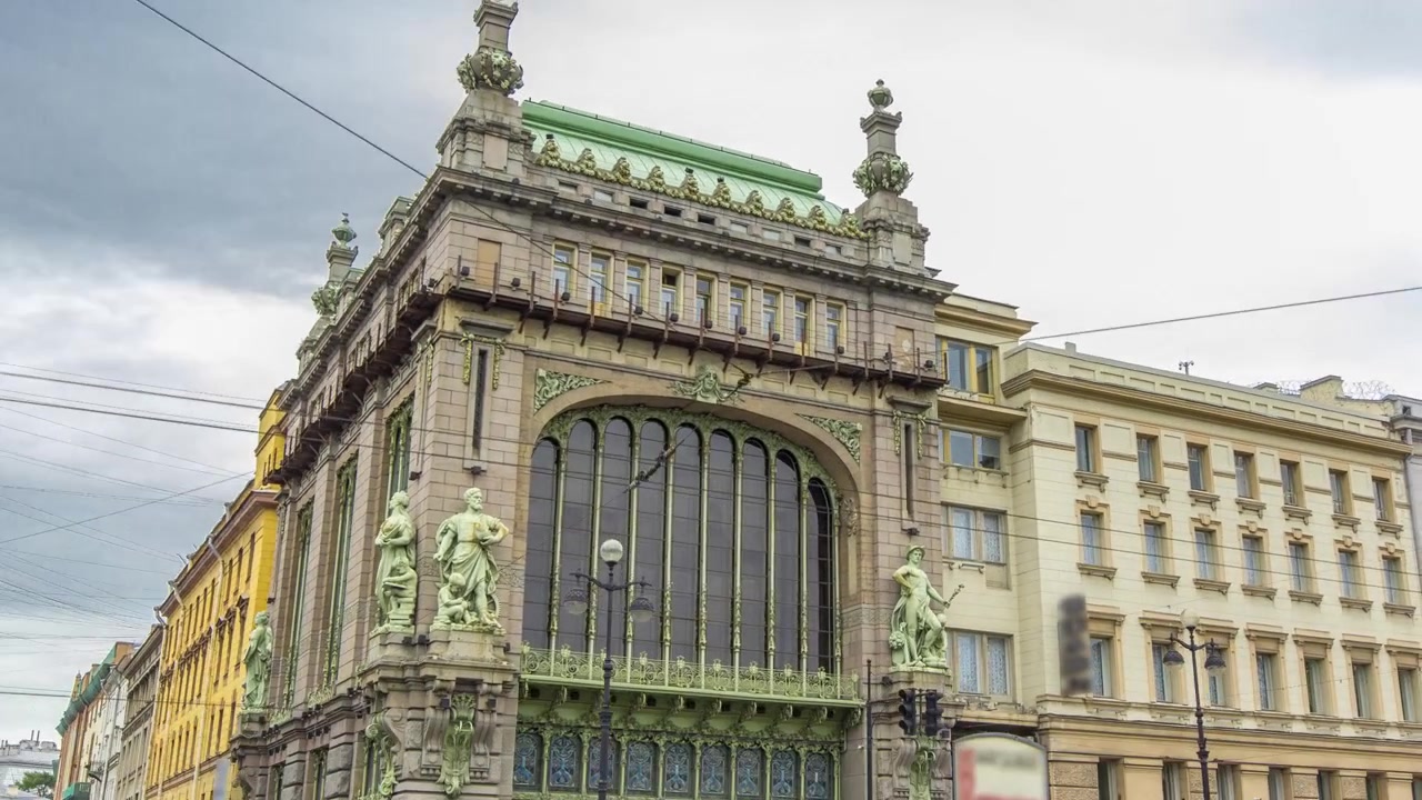 Timelapse e hyperlapse dinâmico do trânsito na Nevsky Prospekt, perto da Loja Eliseevsky, com o Teatro de Comédia N.P. Akimova, sob um céu nublado. São Petersburgo, Rússia