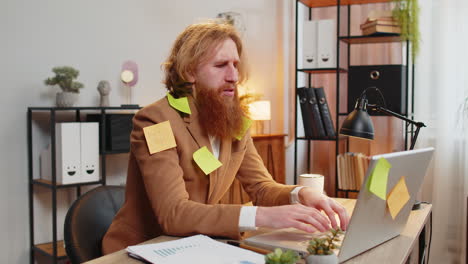 tired exhausted frustrated businessman sits in home office table with laptop sticky notes many tasks