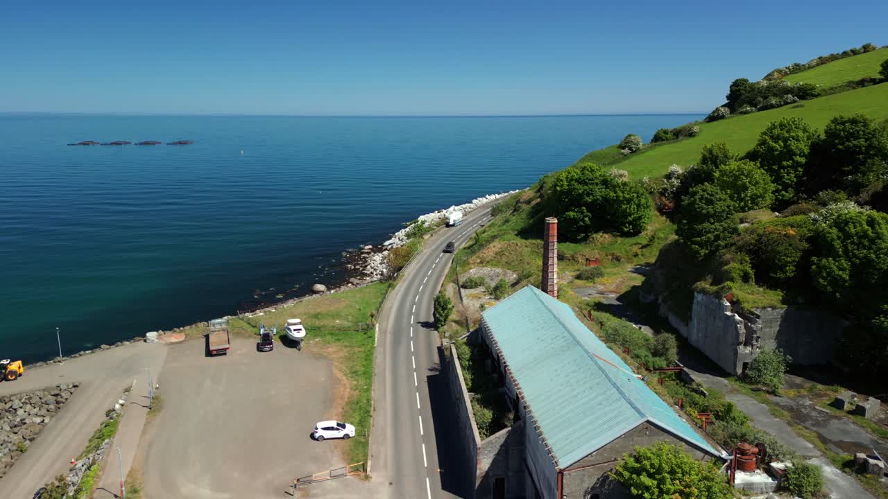 Overhead aerial video of Glenarm Bay and the Glenarm Harbour Chimney, on the Causeway Coastal Route in Northern Ireland, on a bright and sunny day. Filmed in 4K, 60FPS and with Rec709 color.