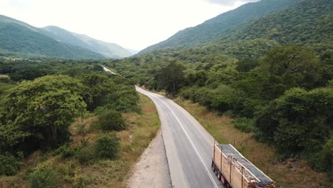 Vista-Aérea-De-Las-Verdes-Llanuras-En-Las-Montañas-Y-La-Carretera-De-Tráfico-Con-Pista,-Tanzania,-áfrica