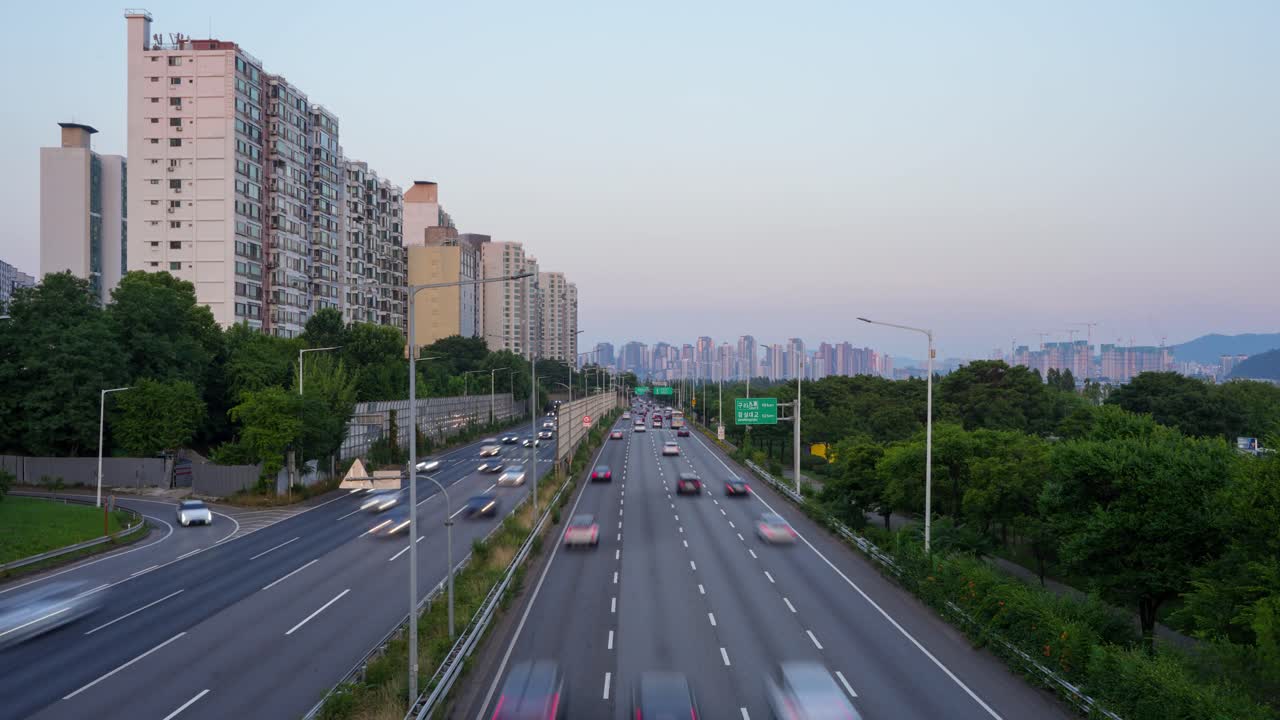 Sunset timelapse of highway traffic in Yongsan district, Seoul, with high-rise apartments and distant skyline views