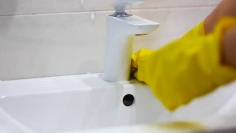 hands of women disinfects sink and washbasin with disinfectant as a prevent of covid-19  and other microbes