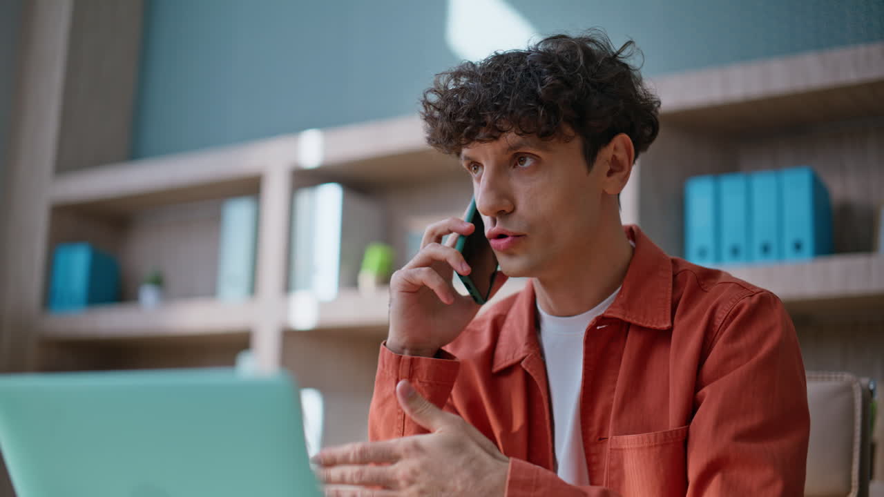 Serious entrepreneur calling partners sitting workspace closeup. Man talking