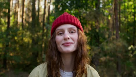 mujer con sombrero de punto rojo en un bosque