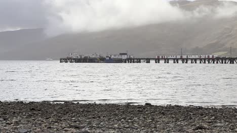 the pier in fort william seen from the shore of loch eil