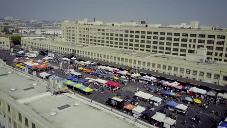 aerial view of a bustling outdoor market with vendor stalls and attendees