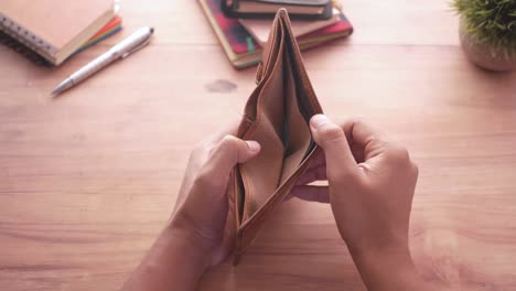 el hombre abre una billetera vacía con espacio para copiar.