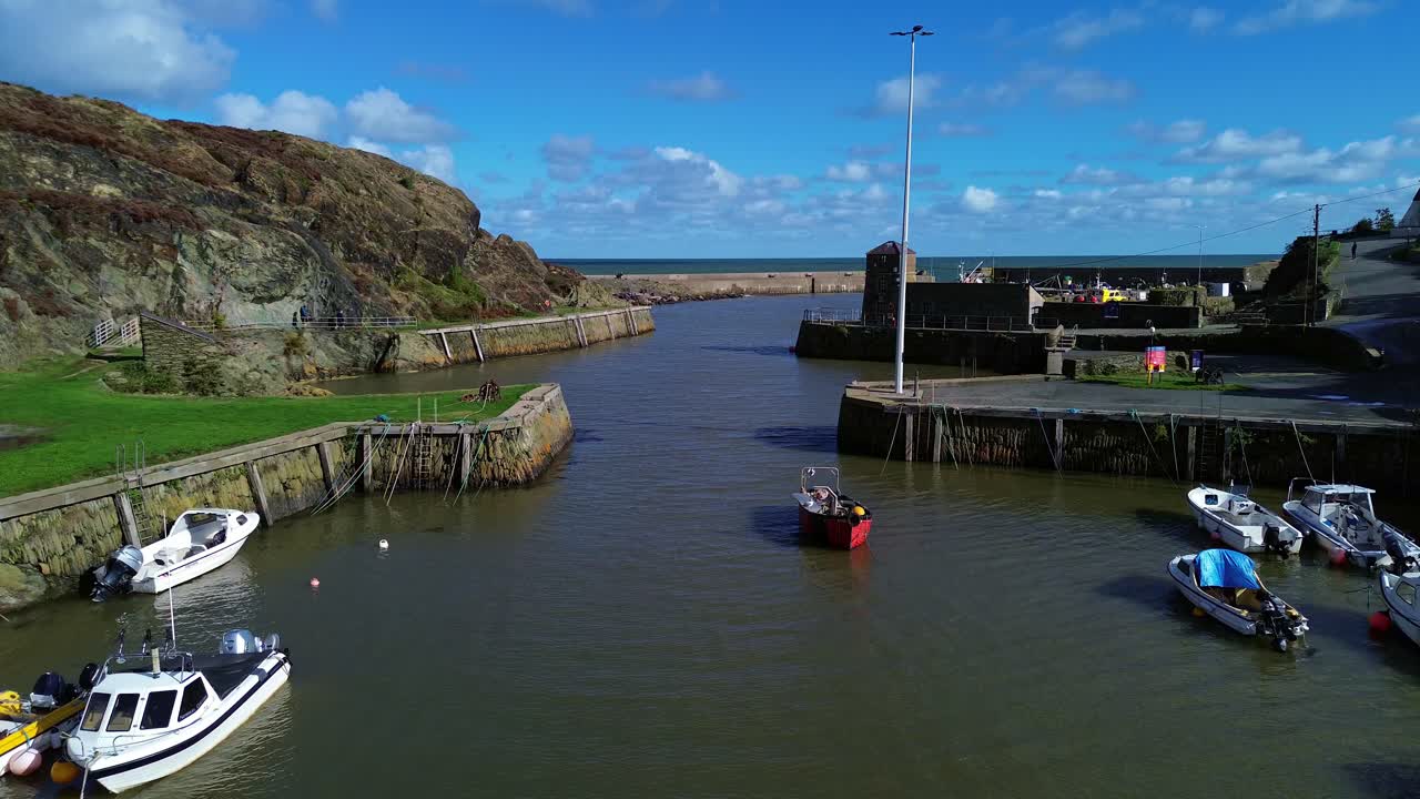 Amlwch harbour aerial view flying over sunny Welsh town waterway passing fishing boats