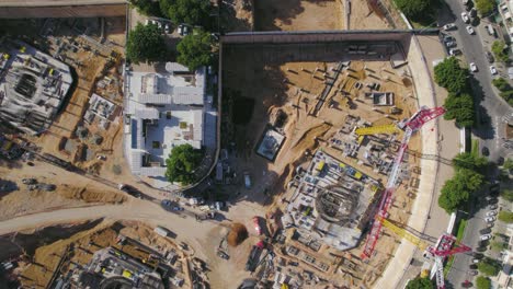 de arriba hacia abajo sobre la grúa torre en el sitio de construcción en una gran plaza - un dron disparó a la izquierda en tel aviv, israel