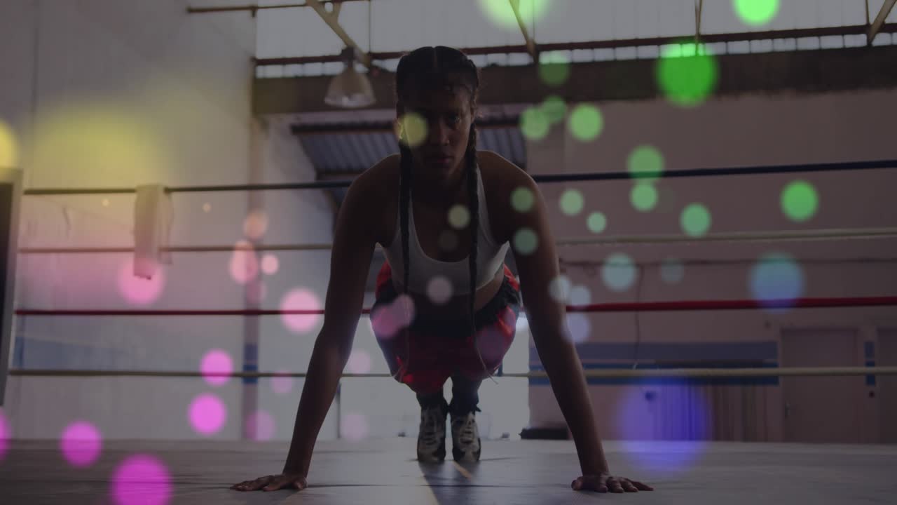 Atleta femminile che esegue flessioni sul ring di pugilato, iniziando un plank e creando un bokeh dinamico per il fitness.