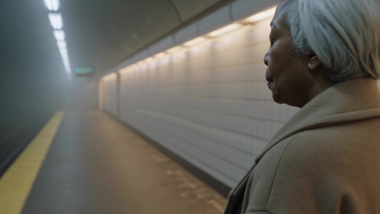Moving shot showing woman waiting for train on subway platform coat tactile strip, copy space